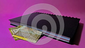 A 5000 Sri Lankan rupee note inside a book on a pink background