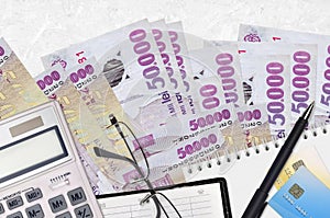 50000 Romanian leu bills and calculator with glasses and pen. Tax payment concept or investment solutions. Financial planning or