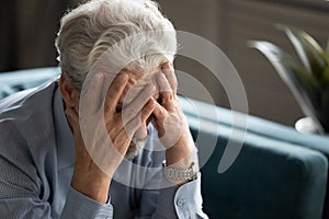 50s man hides his face with hands looking desperate closeup