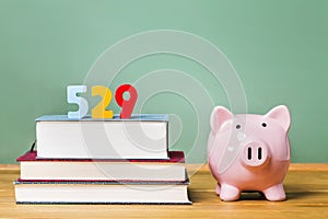 529 college savings plan theme with textbooks and piggy bank