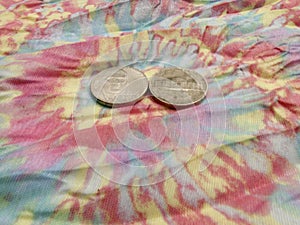 55, two nickels birthday on a pastel tye dyed tapestry.