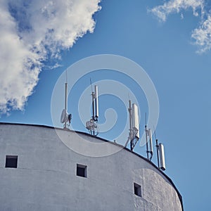 5g cellular antennas receiver on the roof of the building, copy space blue sky