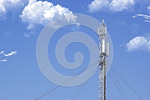 5G technology and telecommunication antenna tower against a blue sky with some clouds. Empty copy space.