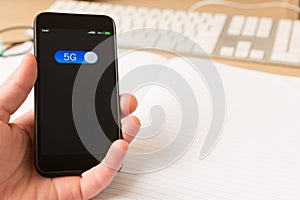 A 5G `wireless technology` button on smart phone device being turned on by the use