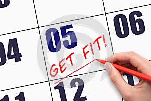 5th day of the month. Hand writing text GET FIT and drawing a line on calendar date. Save the date.