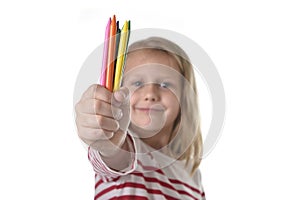 6 or 7 years old beautiful little girl holding multicolor crayons set in art school children education concept