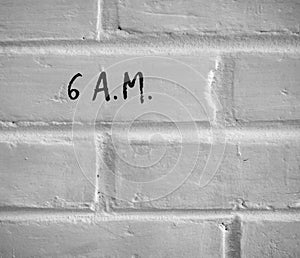 6 A.M. WRITTEN ON WHITE PLAIN BRICK WALL