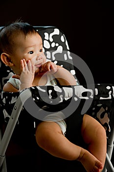 6 month old Asian baby girl chewing fingers