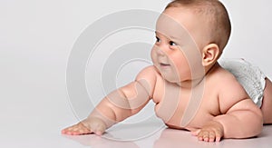 6 month old baby infant lies in one diaper on a light background