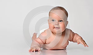6 month old baby infant lies in one diaper on a light background
