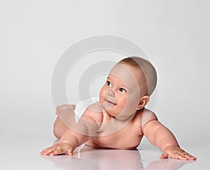 6 month old baby infant lies in one diaper on a light background