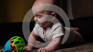 6 month old caucasian infant baby boy playing with toy at home. Early childhood development concept.