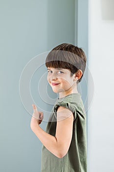 6 year old boy shows band aid on arm to confirm that he got vaccinated.