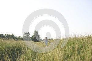 6 year old girl riding a bicycle of a grass covered field.