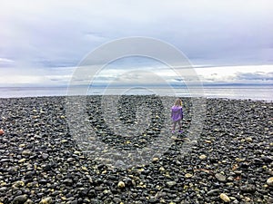 A 6 year old girl walking the beaches of Sooke, facing the open ocean of Juan de Fuca Strait.
