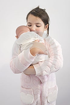 6 years little girl holding affectionately her reborn doll