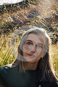 60-year-old European woman against  background of nature