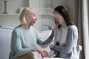 60s mom calming grownup daughter giving support showing care