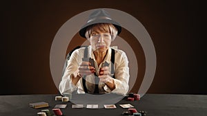 65-Year-Old Woman Analyzing Poker Hand in Dark Room