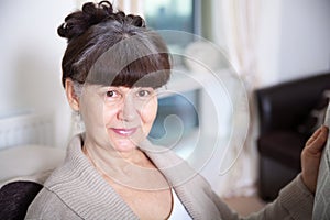 65 years old good looking woman portrait in domestic environment.