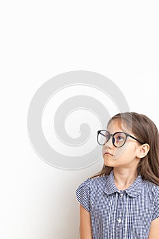 A 7-year-old girl with glasses with sad faces. Children's education, learning concept with copy space. Vertical format
