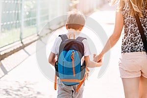 7 years old boy going to school with his mother