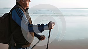 70s aged man Scandi walking stick sport retirement hobby physical activity at sunset beach