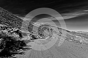 720nm infrared desert dirt road along side a mountain under s dark sky