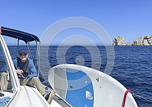 76 year-old Caucasian male tourist ready to take some pictures on a sailboat tour from Cabo San Lucas.