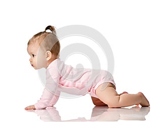 8 month infant child baby girl toddler learning how to crawl in pink shirt looking at corner