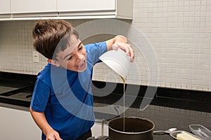 8 year old child pouring condensed milk into the pan and trying to eat it