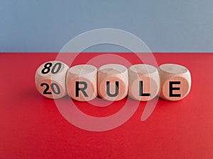 80 on 20 rule symbol. Pareto principle. Turned wooden cubes with words 80 on 20 rule. Beautiful red table, blue background, copy