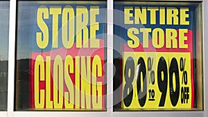 80 to 90 percent OFF. Store Closing. Store Closing Liquidation Sale, Everything on Sale Banners in front of a closing store