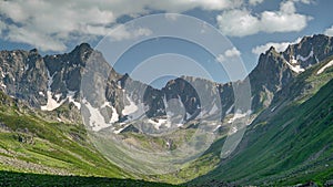 8K Glacial Valley and Alpine Meadow in Front of Rocky Mountain Peaks