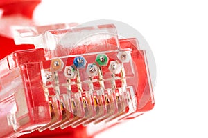 8P8C, RJ-45 crimped red ethernet connector macro, extreme closeup on end, pins, unshielded twisted pair UTP internet cable up