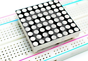 8x8 LED arduino matrix attached to a breadboard on white background. Concept of a technical project.