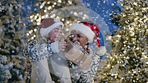 9-10 year old boy in xmas hat admiring magical snowfall, receiving gift from mom