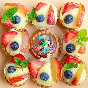9 chiffon/cream cakes basket with fruits, top view. Concept of difference