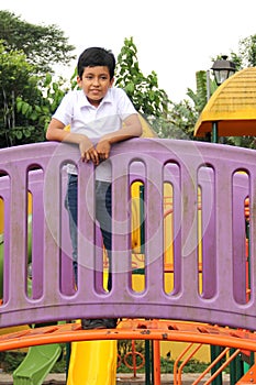 9-year-old dark-skinned Latino boy plays outdoor park games during his vacation in poverty