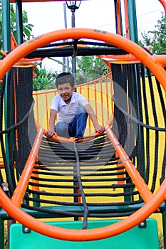 9-year-old dark-skinned Latino boy plays in a playground as a physical activity living in poverty as therapy for ADHD