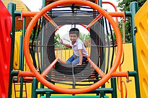 9-year-old dark-skinned Latino boy plays in a playground as a physical activity living in poverty as therapy for ADHD