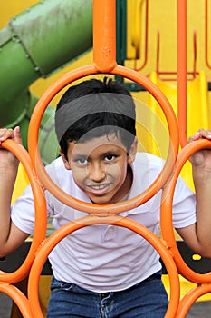 9-year-old dark-skinned Latino boy plays in a playground as a physical activity living in poverty as therapy for ADHD