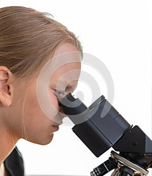 A 9 year old girl looks into an eyepiece of a microscope. Isolated against white background