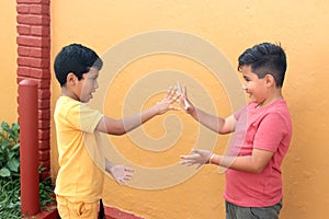 9-year-old Latino children play Scissors, Paper or Stone for fun without video games