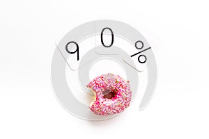 90% off discount - sale concept with bitten donut - on white background top-down copy space