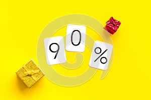 90% off discount - sale concept with present box - on yellow background top-down copy space