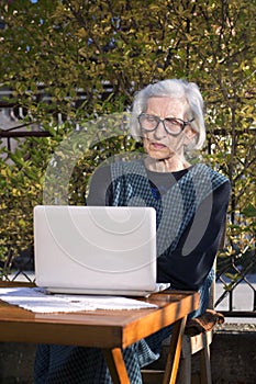 90 years old woman having a video call on a notebook