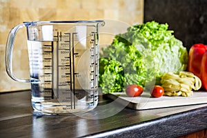 900ccm / 900ml Of Water In A Measuring Cup On A Kitchen Counter With Food