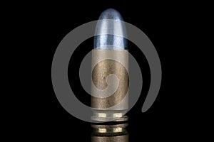 9mm caliber round isolated on black with reflexion