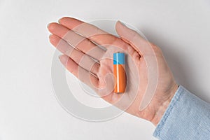 AA alkaline battery lying on the women`s hand. Generic accumulator on white background photo